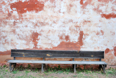 Empty bench against wall