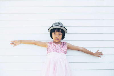 Portrait of a girl standing against wall