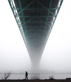 Low angle view of person walking on bridge