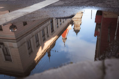 Reflection of people walking on puddle