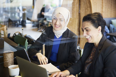 Businesswomen using digital tablet in cafe