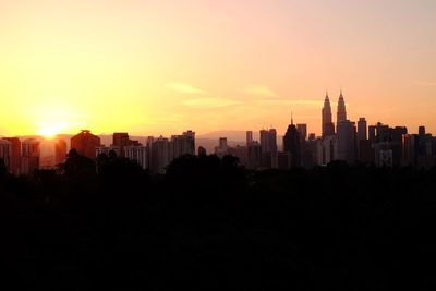 Silhouette of buildings in city during sunset