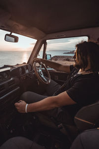 Rear view of woman sitting in car