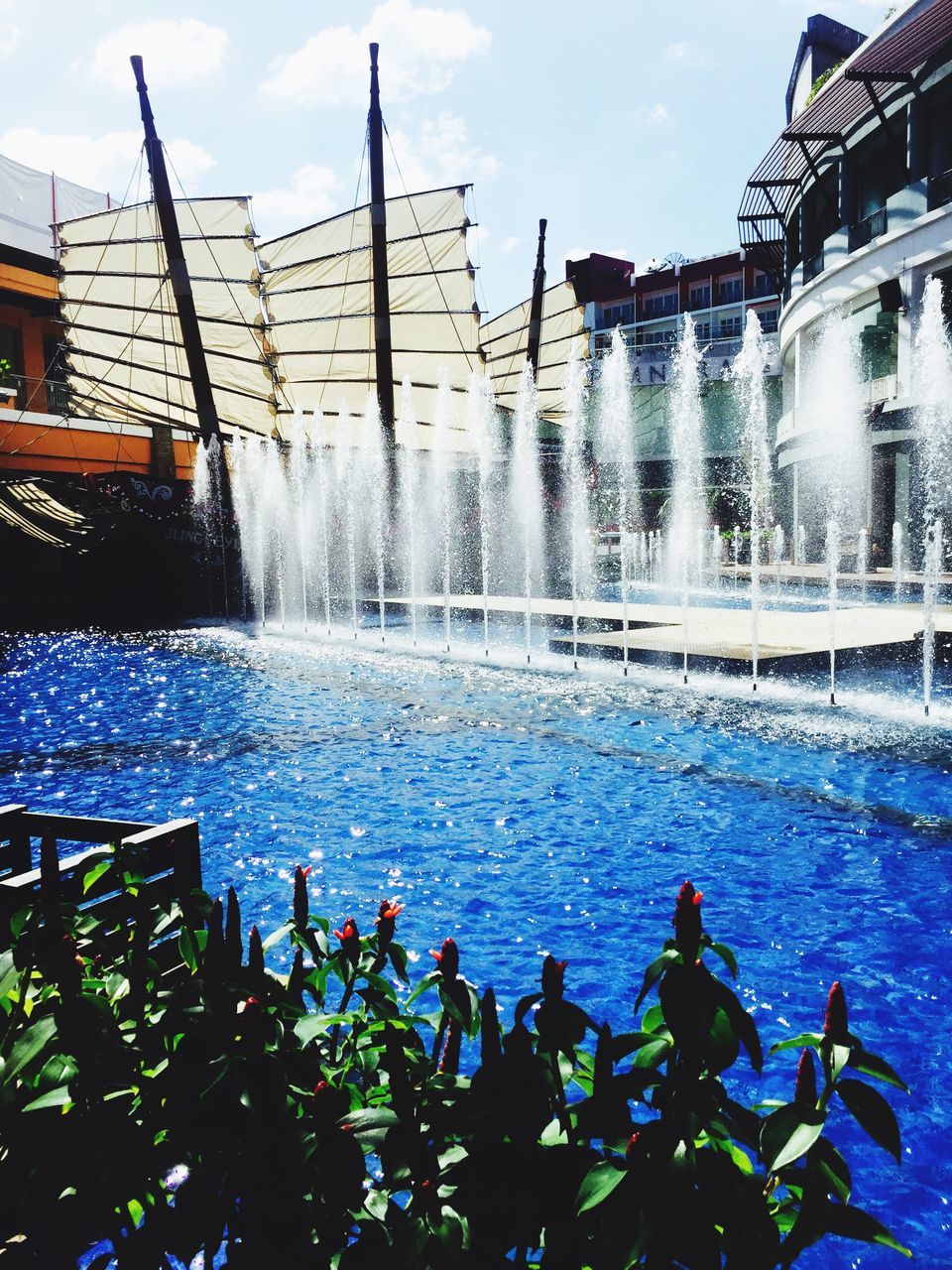 water, building exterior, architecture, built structure, fountain, swimming pool, reflection, motion, blue, city, building, spraying, waterfront, splashing, day, men, lifestyles, sky, leisure activity