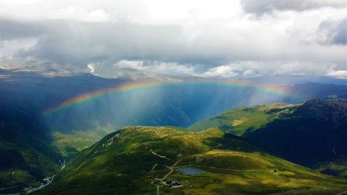 Scenic view of rainbow over mountain against sky