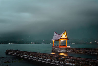 Lifeguard hut on sea against sky at dusk