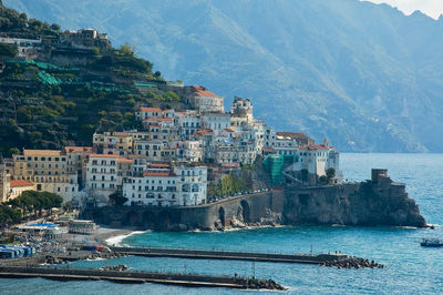 Scenic view of sea by buildings in city