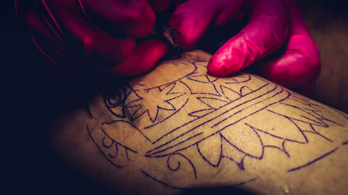 Cropped hands of tattoo artist at work