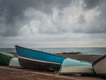 Ship moored on beach against sky