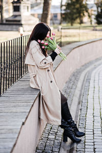 Spring, self love, self care. candid portrait of happy woman with tulips bouquet outdoors