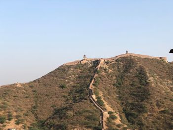 Low angle view of rocks on mountain against clear sky