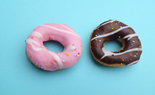 
chocolate and strawberry donuts on a blue background.