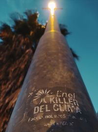Low angle view of illuminated text on building against sky