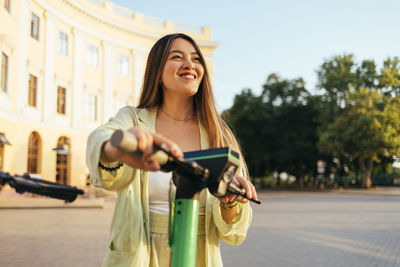 Young woman using phone while standing in city