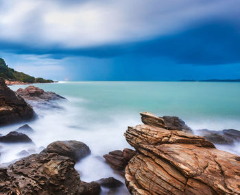 Scenic view of rocks in sea against sky