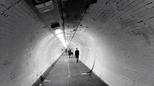 Rear view of silhouette man walking in tunnel