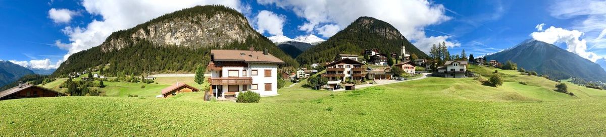 Panoramic view of houses and mountains against sky