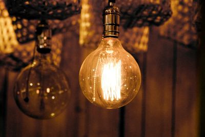 Close-up of illuminated light bulb hanging