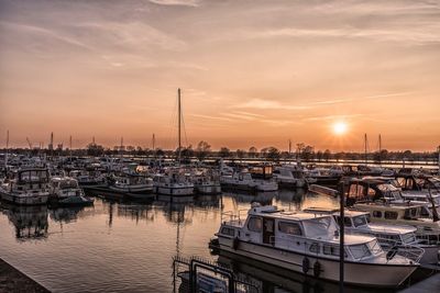 Boats in harbor at sunset