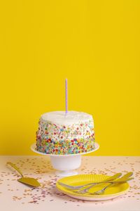 Close-up of cake on table against yellow background