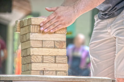 Close-up of man holding stack of wood