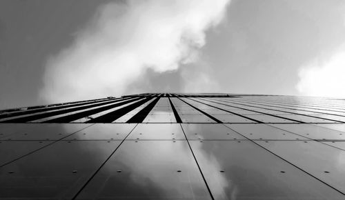 Low angle view of modern building against cloudy sky