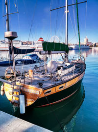 Sailboats moored in sea against sky