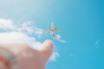 Low angle view of airplane flying against sky