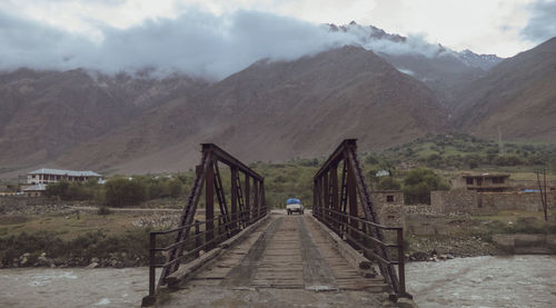 Bridge over mountains against sky
