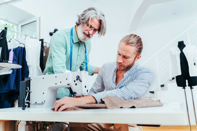 Male fashion designers working at boutique