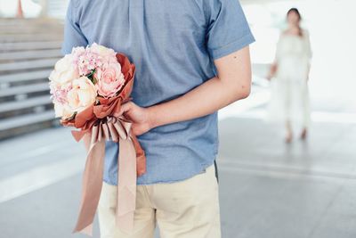 Low section of people holding bouquet