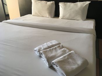 High angle view of folded towels on bed in hotel room