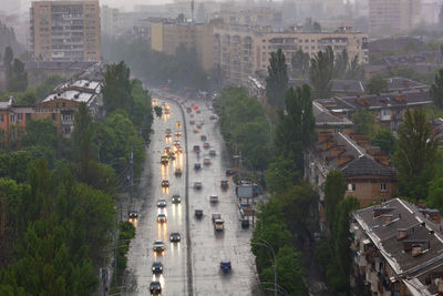 The lights of passing cars are blurred, their reflection on the wet road in heavy rain.