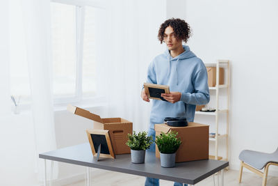 Side view of man using mobile phone while sitting at home