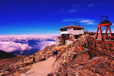 People hiking on mountain against sky