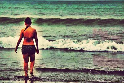 Rear view of woman standing in water