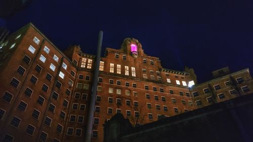 Low angle view of illuminated buildings against sky at night