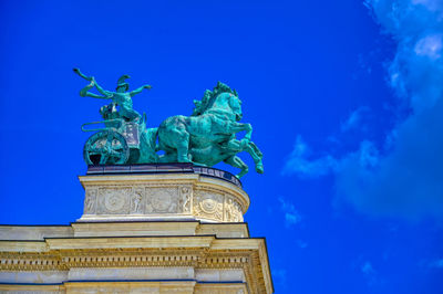 Low angle view of statue against blue sky