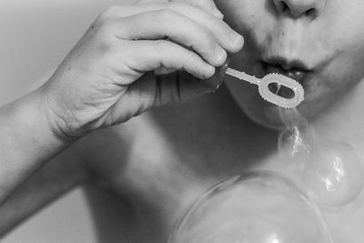 Close-up midsection of boy blowing bubbles