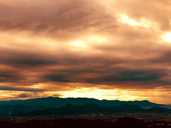 Scenic view of silhouette mountains against dramatic sky