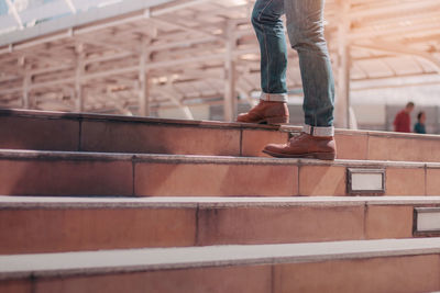 Low section of man standing on staircase