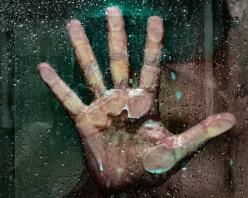 Close-up of human hand on glass