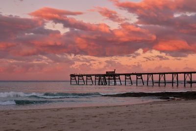 Pier over sea against sky during sunset