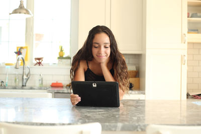 Young woman using phone while standing on table