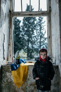 Portrait of boy standing by window