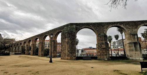 Old ruin bridge against cloudy sky