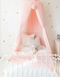Little girl bed with stuffed animal and pink canopy