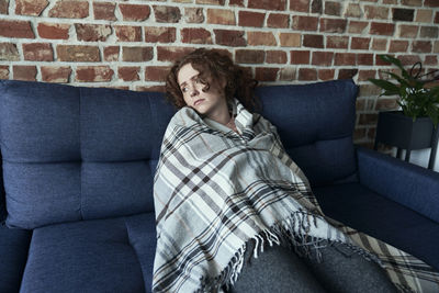 Portrait of woman sitting on sofa at home