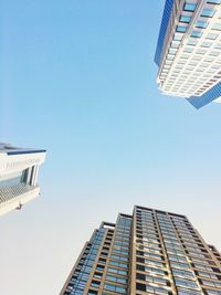 Low angle view of office building against blue sky