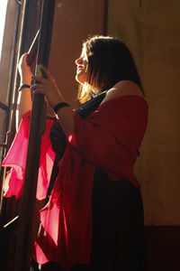 Side view of woman standing by ladder